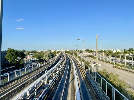 Looking forward from the front of an elevated light rail train towards the Miami skyline