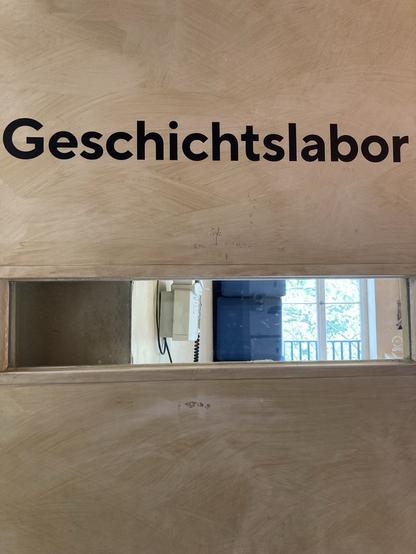 Türausschnitt mit Fensterschlitz mit der Aufschrift Geschichtslabor.