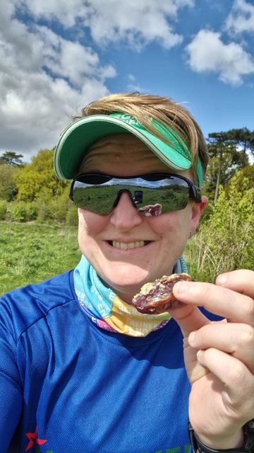 Photo of Ruth in running gear holding up a date filled with peanut butter and smiling