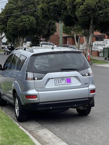 A parked car with a number plate starting with 2 (2AD3xx).