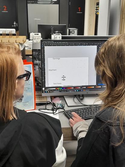 A girl working on her design in inkscape with a facilitator