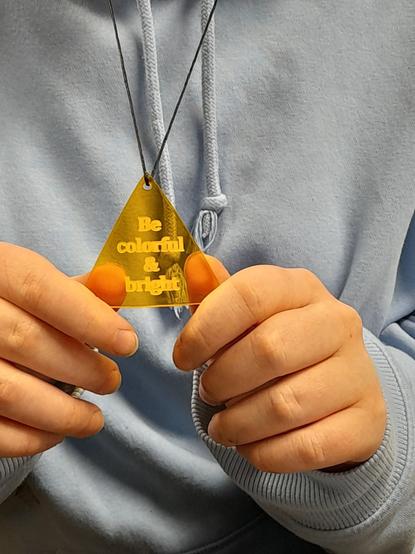 Yellow pendant necklace with the message "Be colirful & bright".