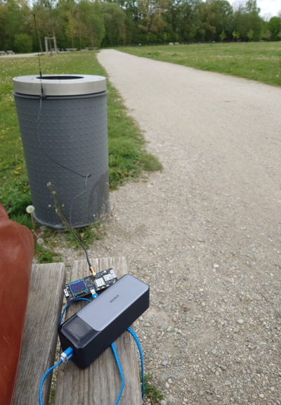 Liligo board with fat power supply and antenna attached to metal dustbin in a park