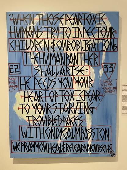 A light blue mural covered in sharp black lined text in all caps