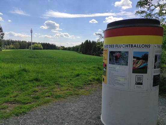 Das Bild zeigt die Wiese bei Naila, also den Landeplatz des Heißluftballons. Rechts ist die Gedenksäule zu erkennen.