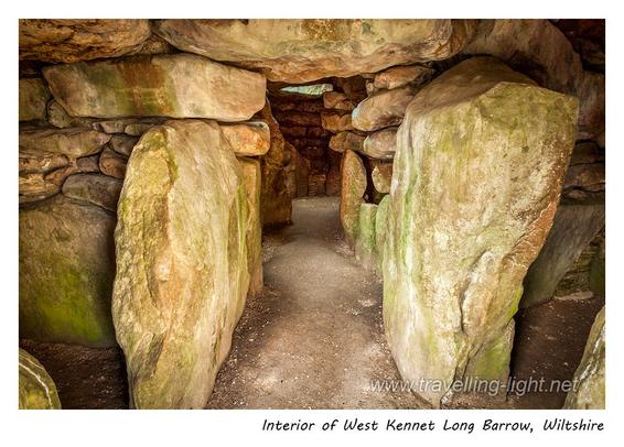 Photo of the inside of an ancient chambered tomb, formed by massive stones, and lit at the far end by a modern skylight.