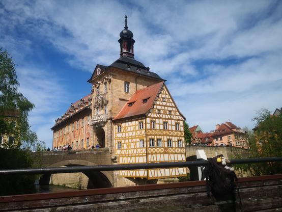Drei Fotos mit dem selben Motiv in leicht unterschiedlichen Formaten und Aufnahmewinkeln:

Das alte Rathaus, aufgenommen von der Geyerswörthbrücke, an deren Geländer der schwarze Rucksack mit den fünf Plüschies hängt.