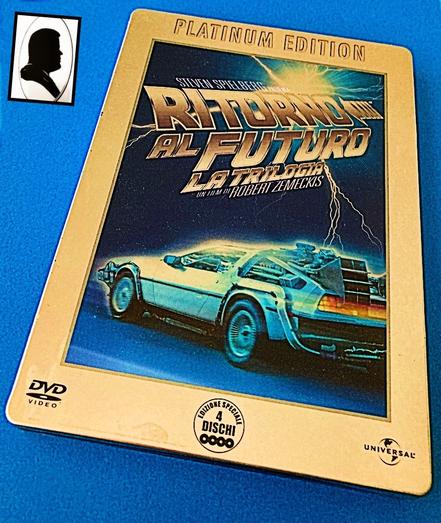 La foto ritrae la copertina del cofanetto di dvd dedicati alla saga di "Ritorno al futuro". Sotto al titolo c'è la famosa macchina del tempo che ha la forma di una Deloran, toccata da un fulmine.