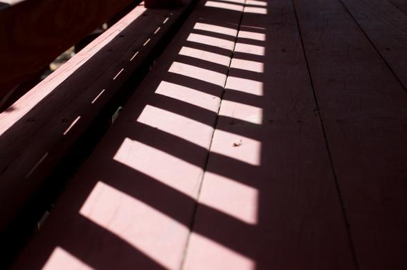 A shadow on a painted board walkway.
