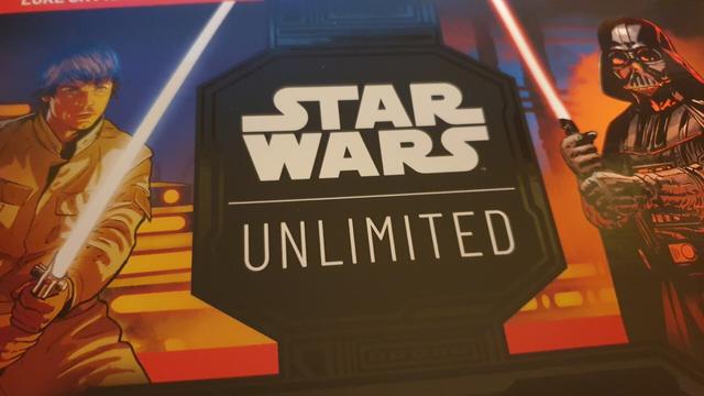 Gros plan sur l'illustration du kit de démarrage de Star Wars Unlimited, avec Luke Skywalker à gauche et Dark Vador à droite.