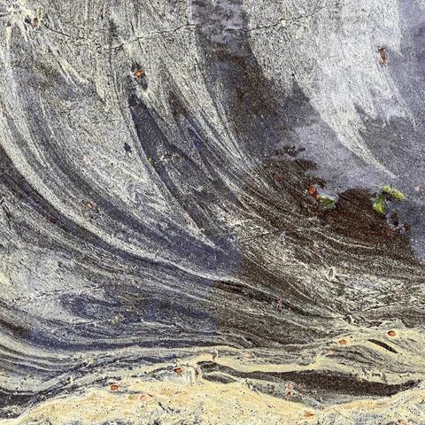 detail of the surface of a puddle. partly covered in yellow pollen gentle wind has created some wave like textures