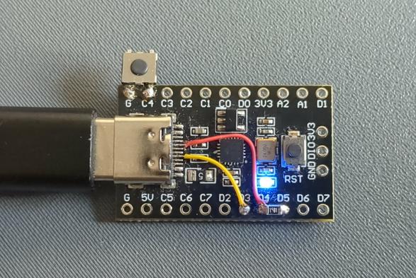Photograph of the board. It uses a nanoCH32V003 off-the-shelf board with a USB mod and a pushbutton soldered to C4.
