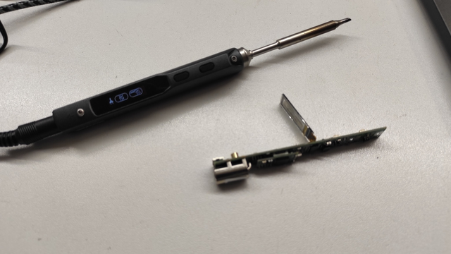 The PCB of a TS-100 soldering iron lying next to a fully assembled and operational TS-100 soldering iron.