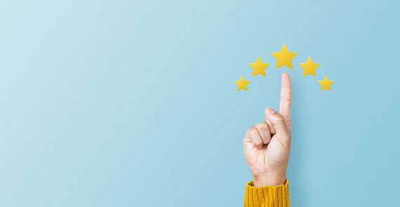 Das Bild zeigt ein Symbolbild zum Thema Ranking: eine Hand, die mit dem Zeigefinder auf den höchsten von fünf Grafiksternen zeigt. Das Foto stammt von AdobeStock/sichon.
