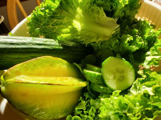 Basket of lettuce, long English cucumber (some sliced pieces in center), mint & a starfruit.