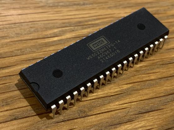 A WDC 65C22N chip in DIP40 packaging on a wooden surface.