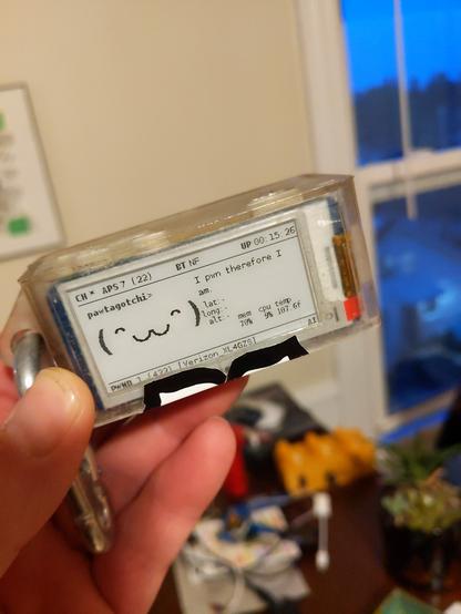 A pwnagotchi, a wifi network analysis tool, with a pleased face on the screen and text stating 'Ipwn therefore I am'