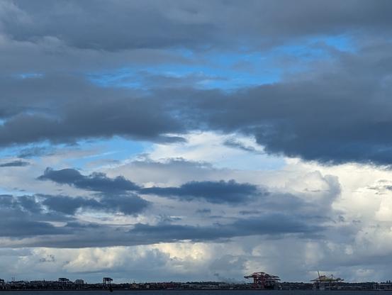 Huge white and blue and shades inbetween rainy sky over port botany