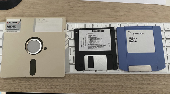 Drei verschiedene Disketten liegen auf meiner Tastatur: (von links nach rechts) 5,25 Zoll für C64, 3,5 Zoll Windows 98 SE Boot-Disk, 100MB ZIP-Diskette