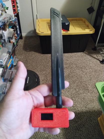LoRa APRS device with bigger 433 Mhz antenna TTGO ESP32 LoRa board inside a 3D printed red case.