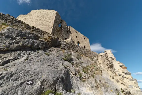 Contre-plongée sur un vestige du chateau, perché sur les rochers.