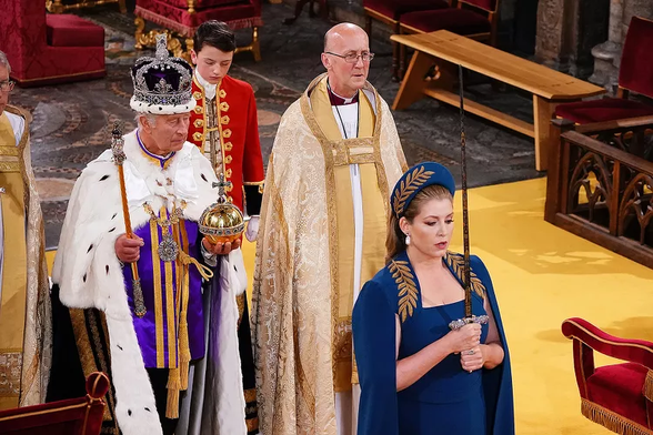 Penny Mordaunt holding the State Sword and leading King Charles in his coronation - photo YUI MOK - WPA POOL/GETTY - https://people.com/royals/king-charles-coronation-penny-mordaunt-sword-carrier-ceremony/