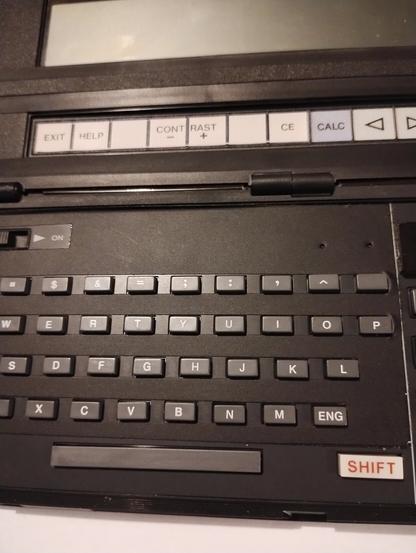 Casio PB-1000 pocket computer, close up of qwerty keyboard with sticker around the buttons to obscure the markings