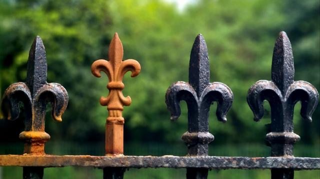 Victorian metal railings with one spike of a very different size and design from the others.