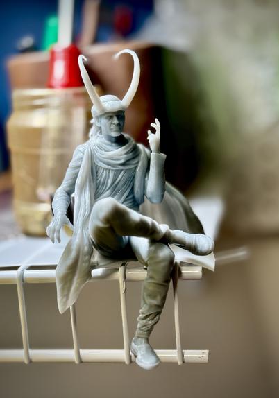 Loki from the MCU sits upon a wire shelf, resin printing 4” tall