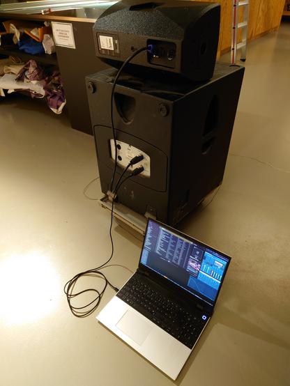 The finished test setup. A loudspeaker on top of a subwoofer to which the USB2Speakon is connected.
A Framework laptop is connected to the other end, providing the power and audio signal.
There is nothing else connected to the speakers other than the USB2Speakon and laptop.