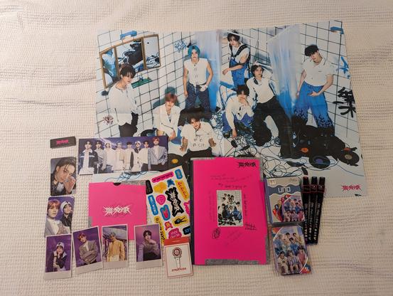 various stray kids merch, most of it from a rock-star album, plus an Uno deck, some skzoo pens, and a lightstick-shaped pin