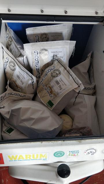 Lastenradkiste voller Papierpackungen mit Haferflocken und Mehl