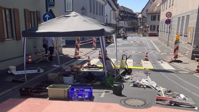 Farbeimer, Kreide im Schattenzelt zum Bemalen einer gesperrten Straße