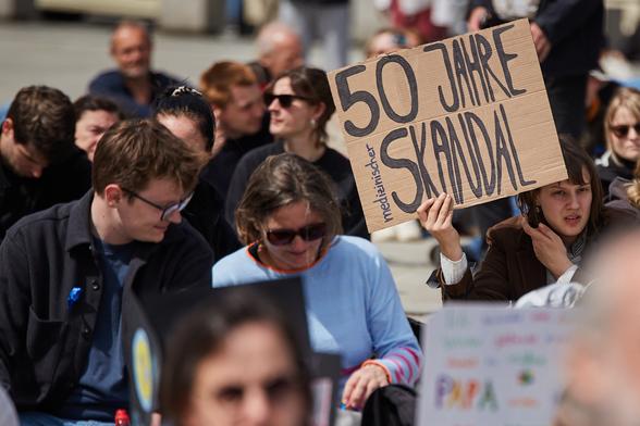 Demo; auf einem Schild ist zu lesen: "50 Jahre medizinischer Skandal".