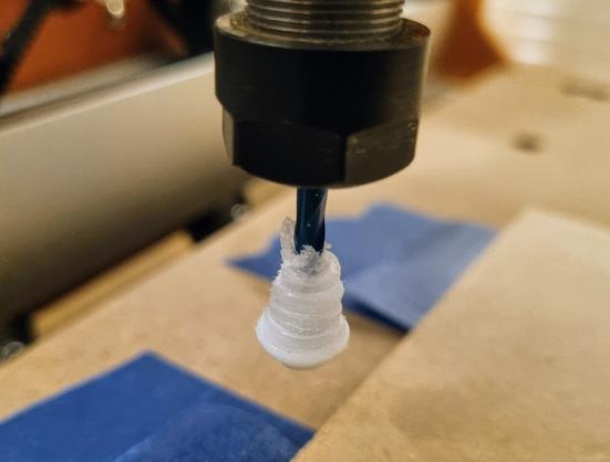 A the "business end" of a CNC router where the bit is encased in a rough cylinder of melted plastic.