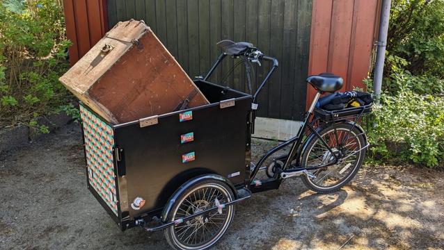 En gammeldags kiste oppi kassa foran på en kassesykkel