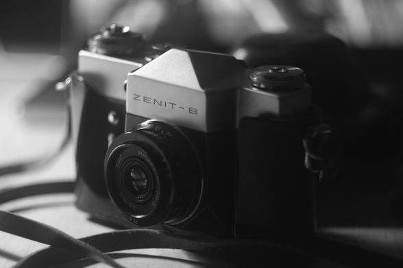 Monochrome processed photo of a KMZ Zenit-B with Industar-50-2 3.5/50 on a table. (CC BY 4.0 - K3.3, Helios 44-2, Hoya Black Mist)