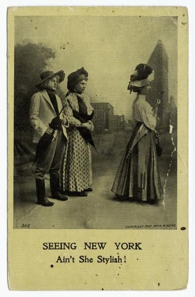 The image depicts a vintage black and white photograph featuring two women. One woman, dressed in a corset with a flared skirt, is standing with her hand on her hip while the other woman, wearing a wide-brimmed hat and long sleeves, stands beside her. Both women are posing in front of a building with a sign that reads "Seeing New York". The photograph has an old-fashioned appearance, reminiscent of early 20th century art. There is text on the image stating "AN'T SHE STILL LOOKS!" which adds to the humor and charm of the scene. The overall mood of the image is nostalgic, capturing a moment from the past.