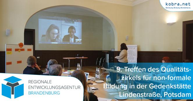Der Raum des 9. Treffen des Qualitätszirkels für non-formale Bildung in der Gedenkstätte Lindenstraße in Potsdam. Das an Tischen sitzende Publikum schaut auf die Beamerprojektion auf der zwei per Videokonferenz zugeschaltete Gästinnen zu sehen sind.