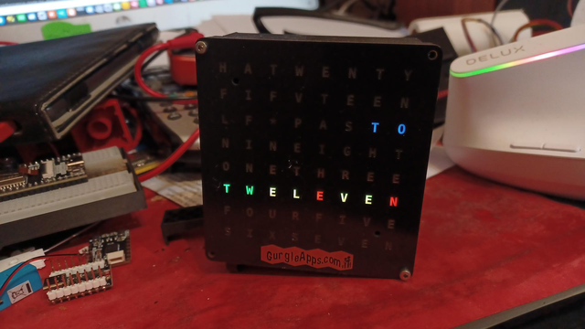 Clock has TO lit up in blue (so at least we know that piece of information)
The 6th line is completely lit up
TW in green EL in yellow, E in red, VE in yellow and N in red

Convention is minutes are in green, hours are in red
Any letters that are lit up in common end up yellow
