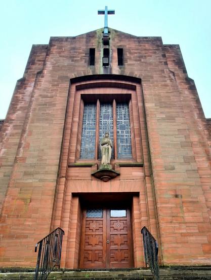 A red sandstone Basilica-style church built in the 1950s.