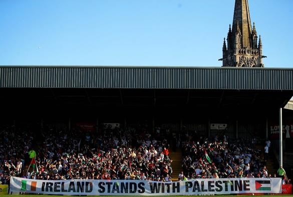 Full stand at football match. Banner in foregound reads "IRELAND STANDS WITH PALESTINE"