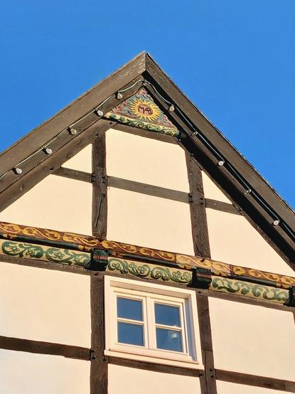 Die Abendsonne scheint auf den Giebel des alten Kornspeichers - ein Fachwerkhaus mit Schnitzereien.