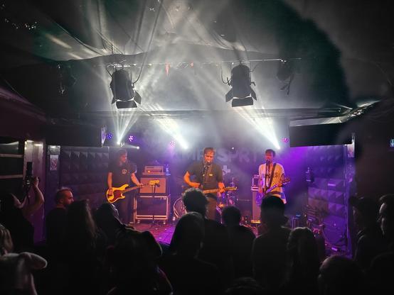 Die Band KMPFSPRT spielt auf einer kleinen Bühne.