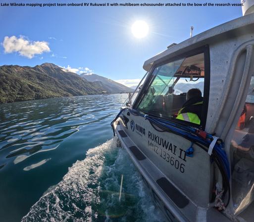 photo - Lake Wānaka mapping project team onboard RV Rukuwai II with multibeam echosounder attached to the bow of the research vessel.
