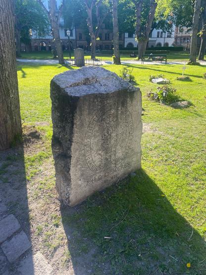 Photo of travestone for the runologist Liljegren. The stone looks like a runestone, with a band of runes on the face.