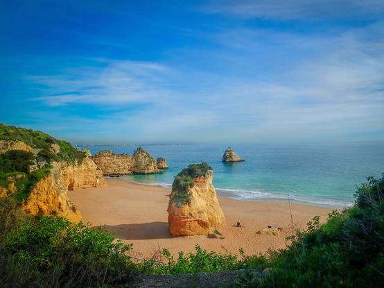 Secluded beach with beautiful cliffs and rock formations in orange sandstone and beautiful Atlantic ocean
