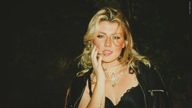 Sängerin Dasha steht mit cooler Lederjacke vor der Kamera. Ihre langen blonden Haare sind verwuschelt. (Foto: Adam Budd)