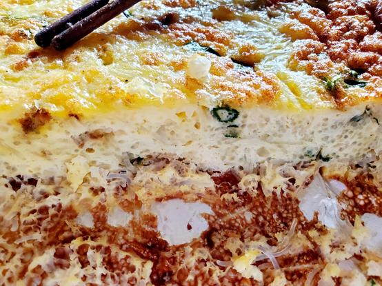 Eggs, Rice Vermicelli with Crab Meat, Water Chestnuts & Green Onions casserole. Sliced close up view in aluminum baking pan.