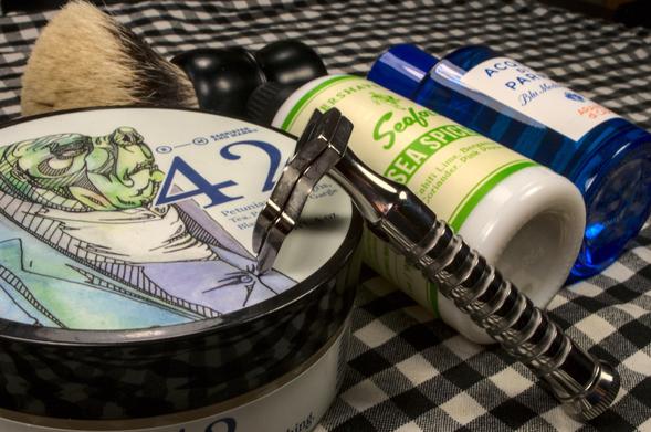 A Razorock Hawk V3 leaning on a tub of BaM 42 with a bottle of Seaforth! Sea Spice Lime toner, AdP Arancia di Capri, and a Dogclaration Mystery B16 brush.